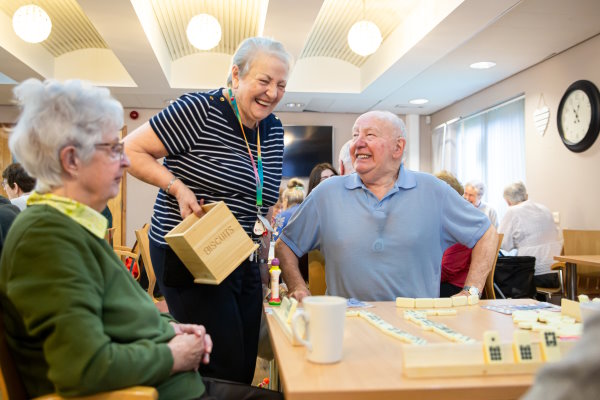 A group of elderly people playing dominoes