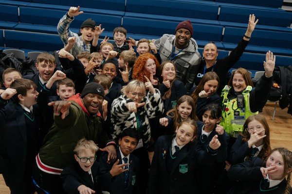 Members of the No More Knives Tour and school children