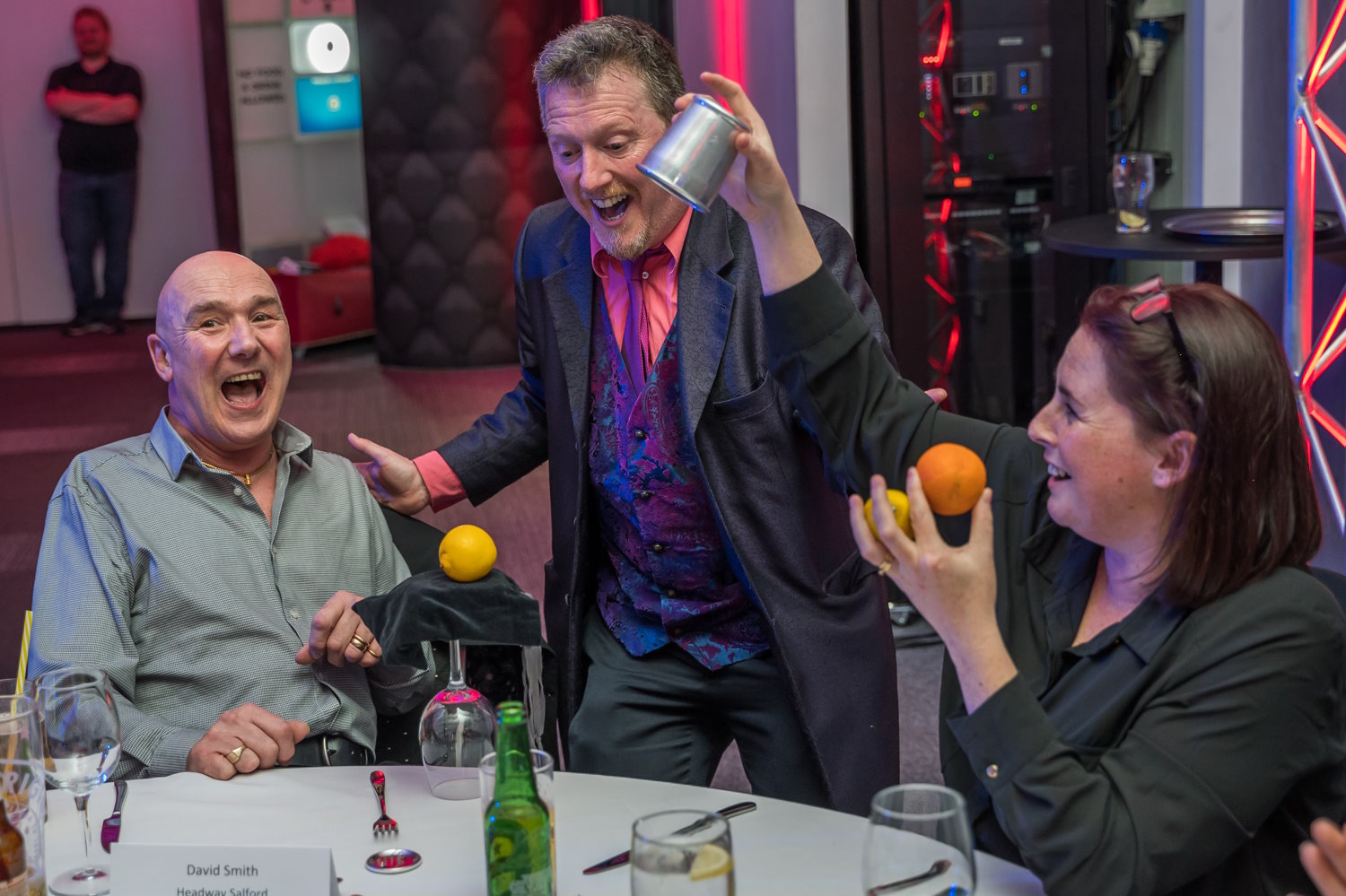 A magician doing a magic trick at one of the tables at the ceremony